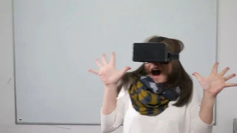 Girl getting scared while playing virtual reality video game with VR glasse.. Video stock 71480069