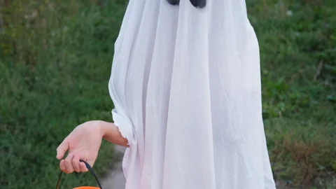 Girl in ghost costume posing with candy basket Stock Footage 315218164
