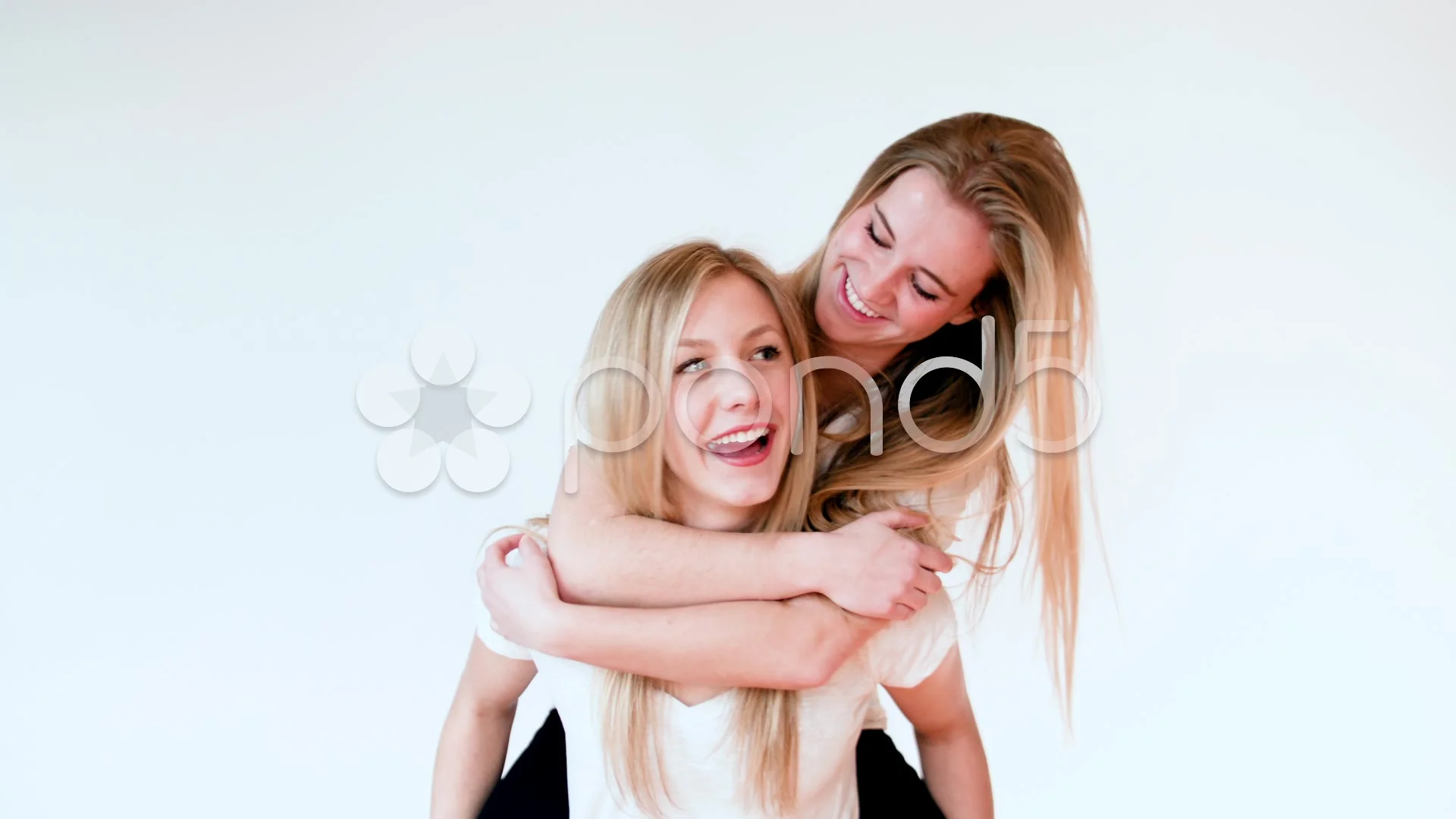 Girl giving her friend a piggyback ride stock photo