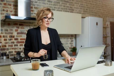 A girl in glasses gesturing while talking to her colleagues in a video call. Stock Photos