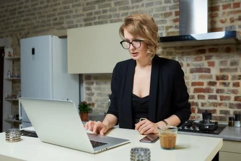 A girl in glasses gesturing while talking to her colleagues in a video call. Stock Photos