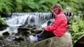 Girl in glasses in the shape of hearts sits near river and talks via tablet pc HD Footage