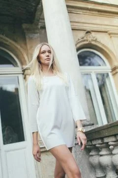 Girl goes against the backdrop of an old house architecture Stock Photos