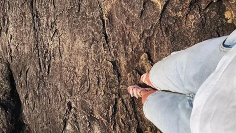 The girl goes down a steep stone slope. the girl is traveling in India Stock Footage 274664681