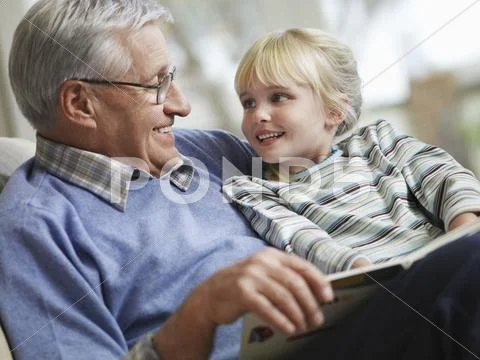 Girl With Grandfather Reading Story Book Stock Photos