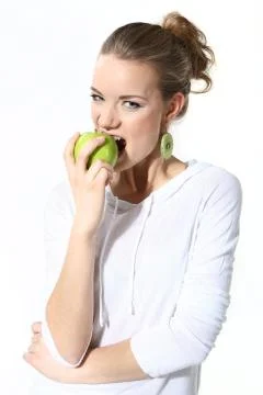Girl with a green apple on a white background Stock Photos