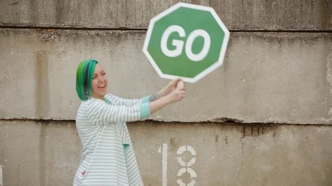 A girl with green hair calls to act. The sign of Motivation goes forward Stock Footage