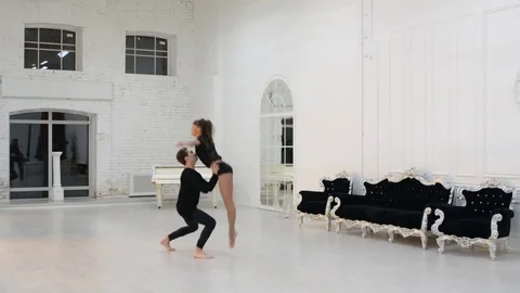 Girl with guy dance gymnastic dance in the dance hall Stock Footage