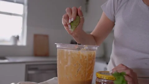 Girl hand squeezing lime in kitchen, cooking food 库存影片 220753612