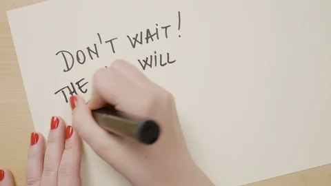 Girl hand writing down do not wait the time will never be just right motivati Stock Footage 88865231