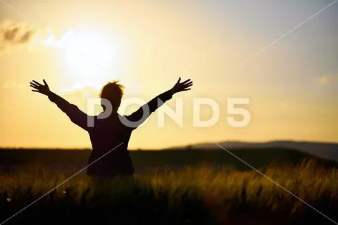 The girl has in the field raised hands to the sun Stock Photos