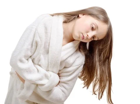 Girl has a stomachache with bathrobe, isolated on white background Stock Photos