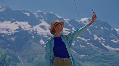 A girl in a hat and with a backpack in the summer in the mountains of Stock Footage 281799076