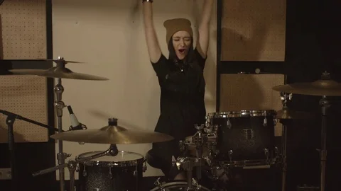 Girl in a hat having fun playing the drums in the studio. Video stock 73185472