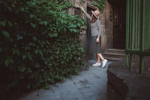 The girl in the hat opens a mailbox with sheets at the background of the old Stock Photos