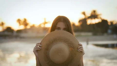 Girl with a hat posing in front of the camera at sunset Stock Footage 129026637