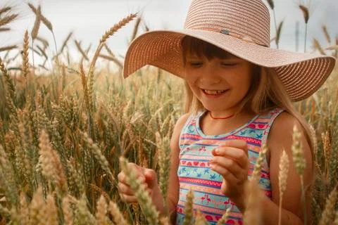 Girl in a hat in a whead field. Stock Photos