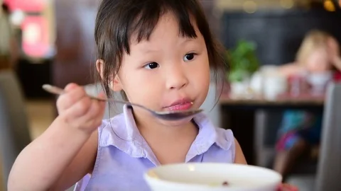 Girl having breakfast on the table Stock Footage 75530886