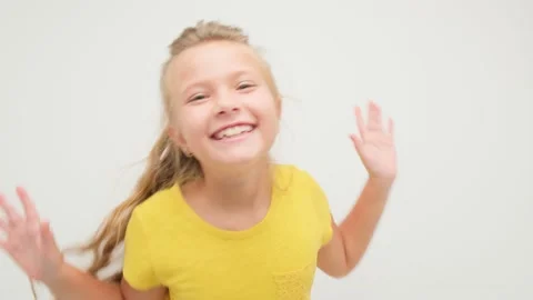 The girl is having fun and dancing on a white background in the studio in a 库存影片 146314872