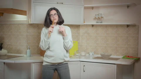 Girl is having fun on the background of the kitchen at home, holding a wooden Stock Footage 167146267