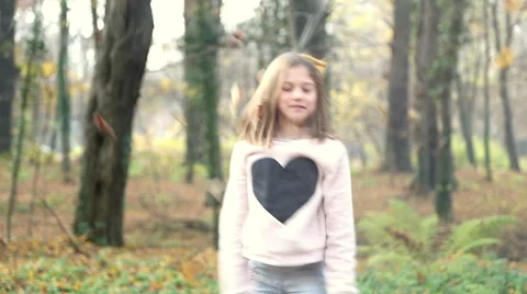 Girl having fun throwing leaves and jumping in the park Stock Footage 59553828