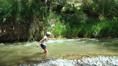 Girl having fun walking on a rough mountain river on a hot summer day Vidéo 279309092