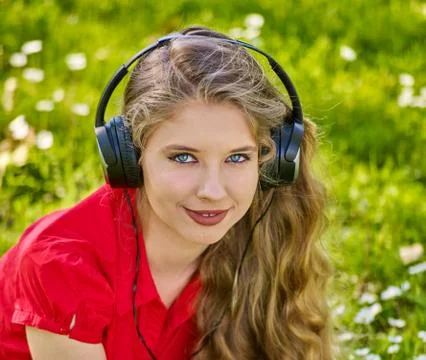 Girl in headphones catch rhythm music on green grass Stock Photos