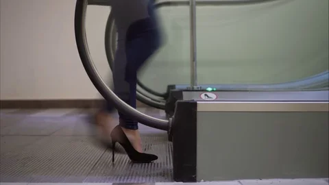 The girl in heels rises up on the escalator Stock Footage 80470267