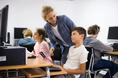 Girl helping boy with computer problem Stock Photos