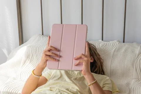 Girl hiding face using digital tablet in bed Stock Photos