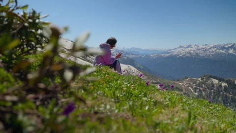 Girl hiker using phone while resting on hillside with great overlook Stock Footage 164412860