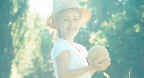 Girl holding and sniffing melon. Child smiling at camera. Child touting melon Video stock 51873353