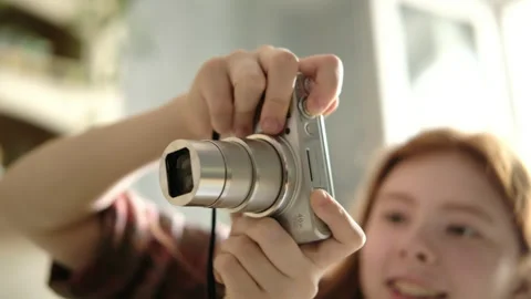 Girl holding a compact digital camera while taking photos Stock Footage 340836220