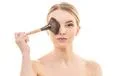 The girl holding a cosmetic brush on the white background Photo