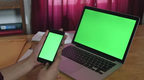 Girl Holding a green screen iphone and macbook pro Stock-Footage 59771827