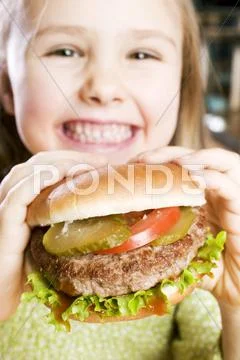 Girl holding large hamburger Stock Photos