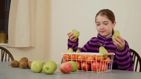 Girl holding pears while sorting fruits. Female placing pears into basket. Lady Stock Footage 309394812