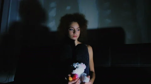 A girl holding a teddy bear and think of something sad Stock Footage 59237457