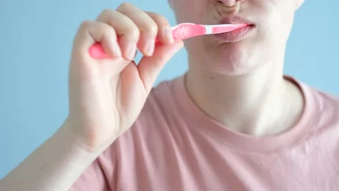 Girl holding a toothbrush with toothpaste on blue background, selective focus. Stock Footage 196044853