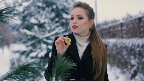 Girl holds bitcoin in hands winter park Slow motion Stock Footage 83211283