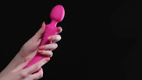 Girl holds in her hands a pink massager   Stock Video Pond5 