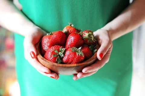 Girl holds a plate of red fresh strawberry Stock Photos