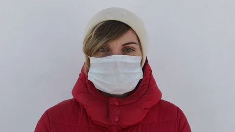 A girl in a hood and mask in the city is infected with a coronavirus Stock Footage