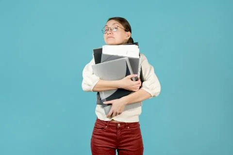 Girl hugs a large stack of documents and folders. Stock-Fotos