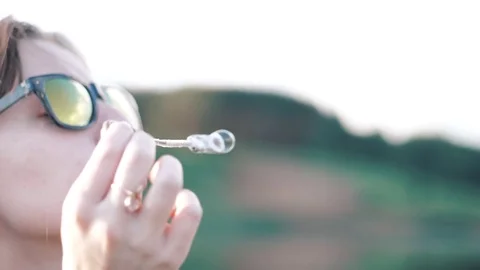 Girl inflates soap bubble Stock Footage