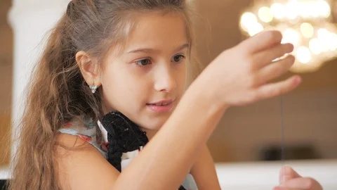 The girl, insert the thread in the needle, starts to sew the mascot doll (motank Stock Footage 120269215
