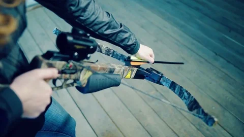 Girl inserts arrow into crossbow Stock-Footage 81928132