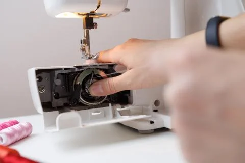 Girl inserts bobbin in sewing-machine 写真素材