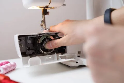 Girl inserts bobbin in sewing-machine Girl inserts bobbin in sewing machin... 写真素材