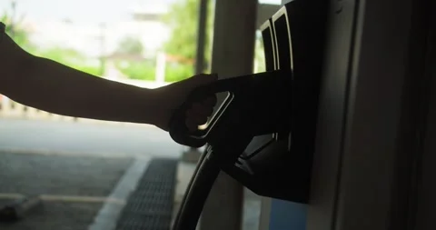 A girl inserts a charging cable into the charging port of an electric car, which Stock Footage 308103099
